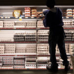 Grocery store worker stocking egg cartons